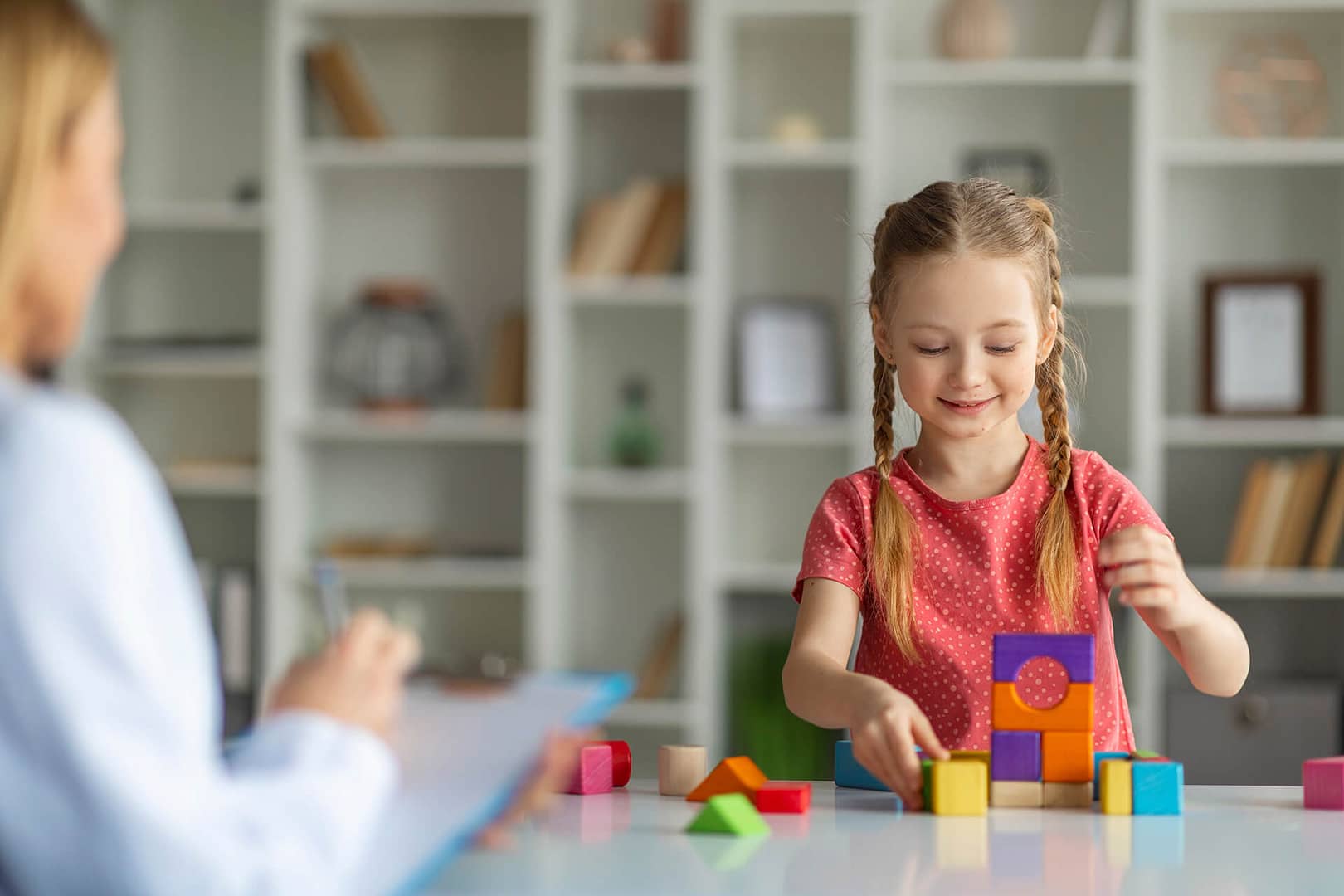 Autism and ADHD Assessments Young girl engrossed in building with puzzle blocks, using play therapy as a tool for development or treatment of eating disorders such as anorexia, bulimia, and binge eating